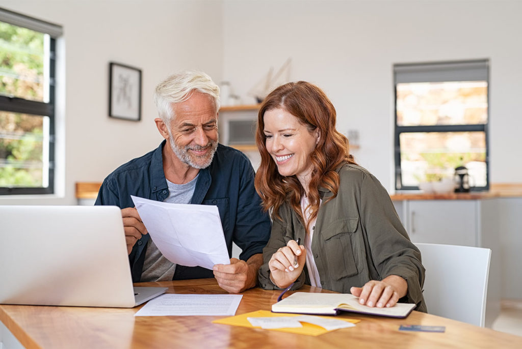 couple in front of their laptop reviewing financial paperwork about to contact fraga financial group orlando fl